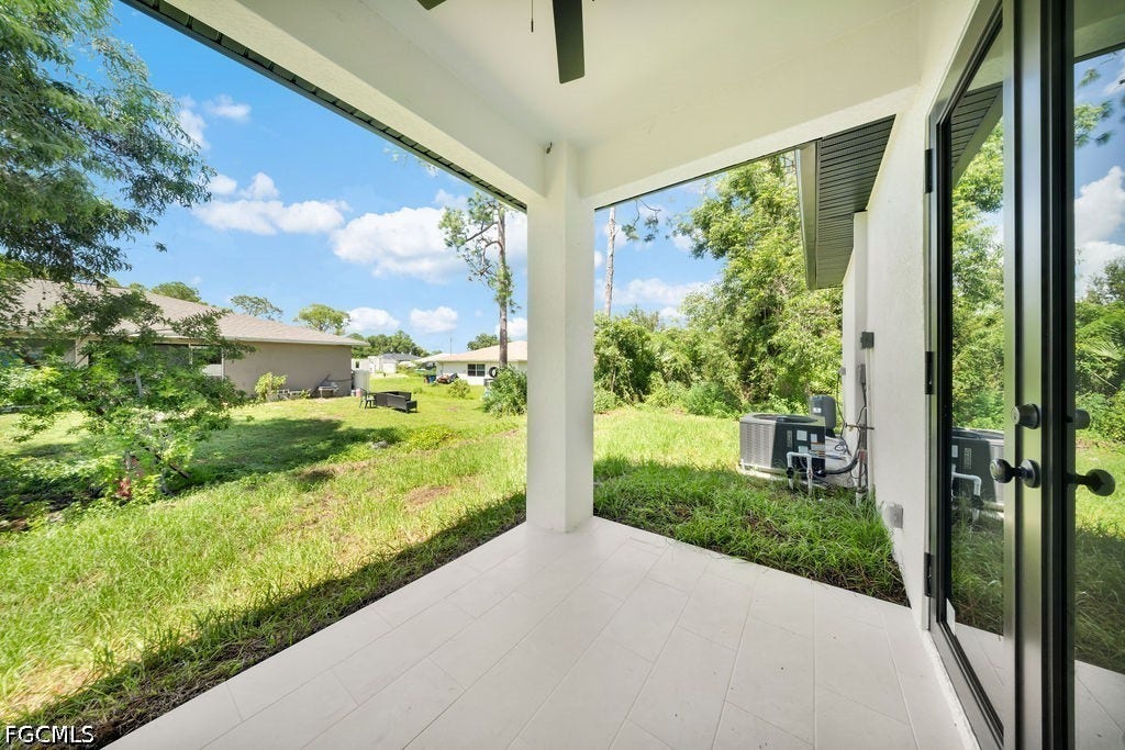 2416/2418 Joe Avenue S, Lehigh Acres, FL 33973 Covered patio with a tile flooring, black frame glass exterior door, and a ceiling fan