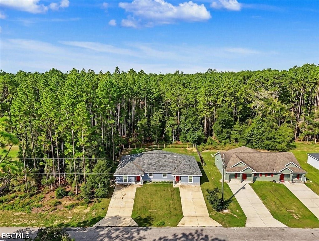 9342/9344 N Peachtree Way, Citrus Springs, FL 34434 Aerial view showcasing two single-story residences situated on expansive grounds bordered by mature pine forest