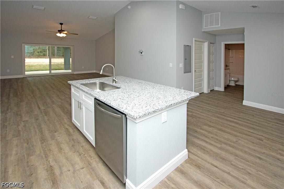 9342/9344 N Peachtree Way, Citrus Springs, FL 34434 Open-concept living area featuring a kitchen island with stone-finish countertop, stainless steel appliances, and wood-finish flooring