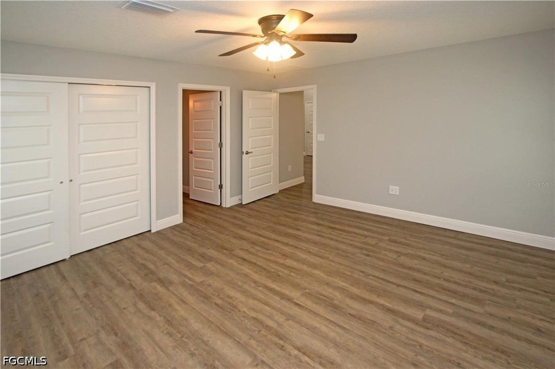 9342/9344 N Peachtree Way, Citrus Springs, FL 34434 Wood-finish flooring, light gray wall paint, white panel interior doors, and a ceiling fan with integrated lighting