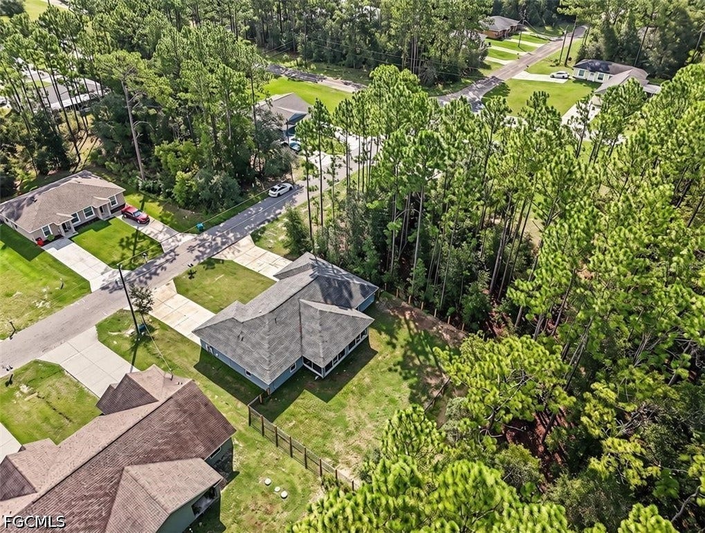 9342/9344 N Peachtree Way, Citrus Springs, FL 34434 Property featuring a shingled roof, fenced perimeter, and surrounding mature trees