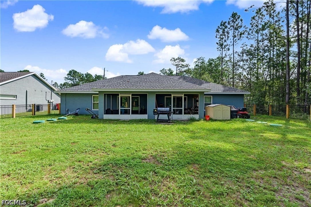 9342/9344 N Peachtree Way, Citrus Springs, FL 34434 Expansive rear yard featuring a screened-in porch, privacy fencing, and mature trees bordering the property