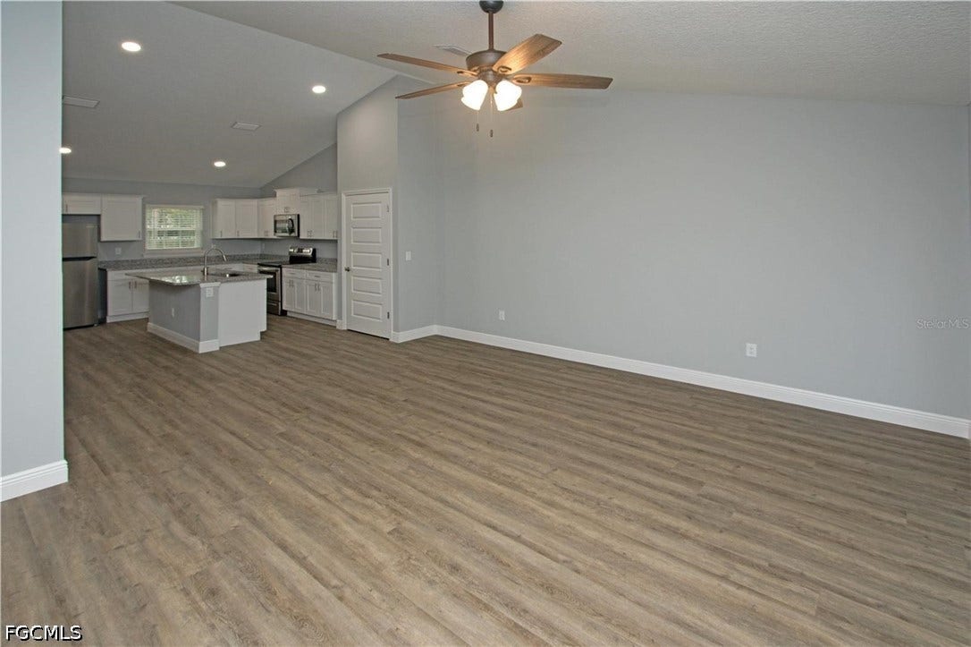 9342/9344 N Peachtree Way, Citrus Springs, FL 34434 Spacious open-concept living area featuring vaulted ceilings, wood-finish flooring, and recessed lighting