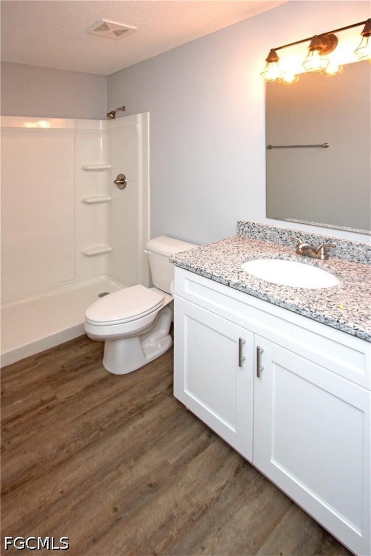 9342/9344 N Peachtree Way, Citrus Springs, FL 34434 White vanity with brushed nickel hardware, granite-style countertop, undermount sink, and wood-finish flooring