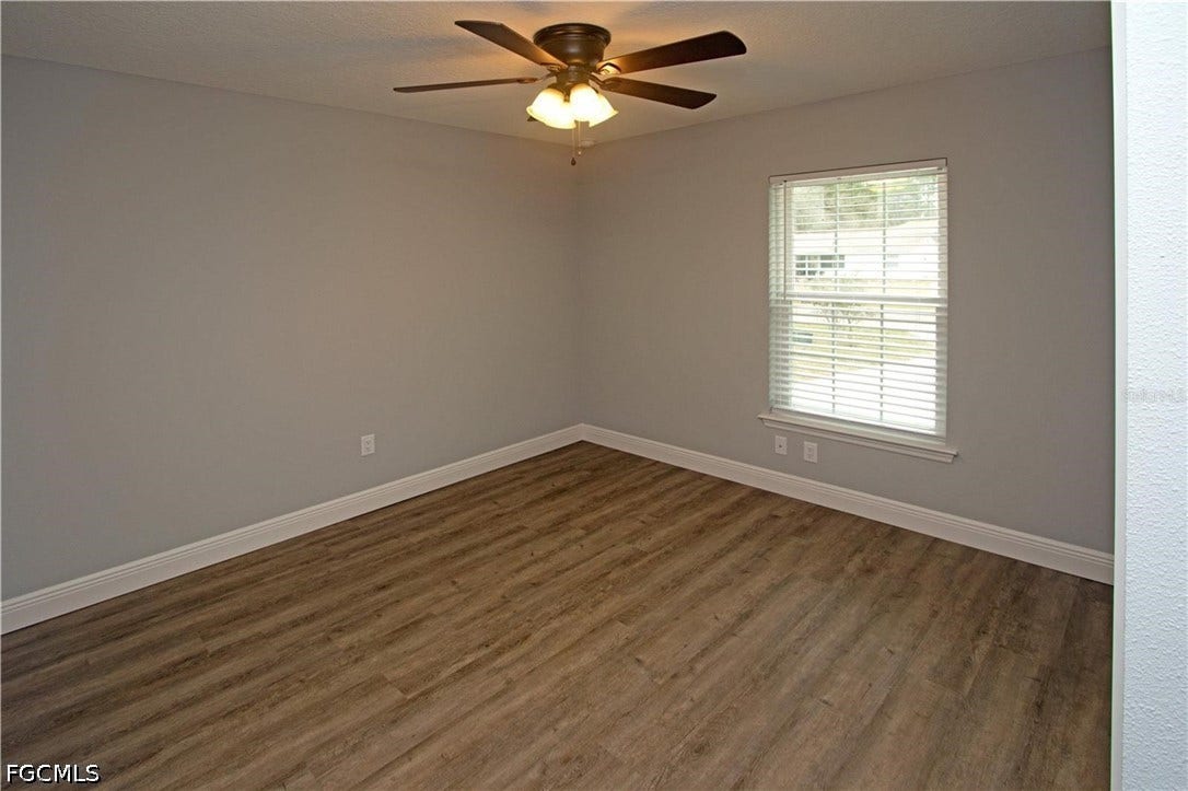 9342/9344 N Peachtree Way, Citrus Springs, FL 34434 Wood-finish flooring, light grey wall paint, ceiling fan with integrated lighting, and a window with horizontal blinds