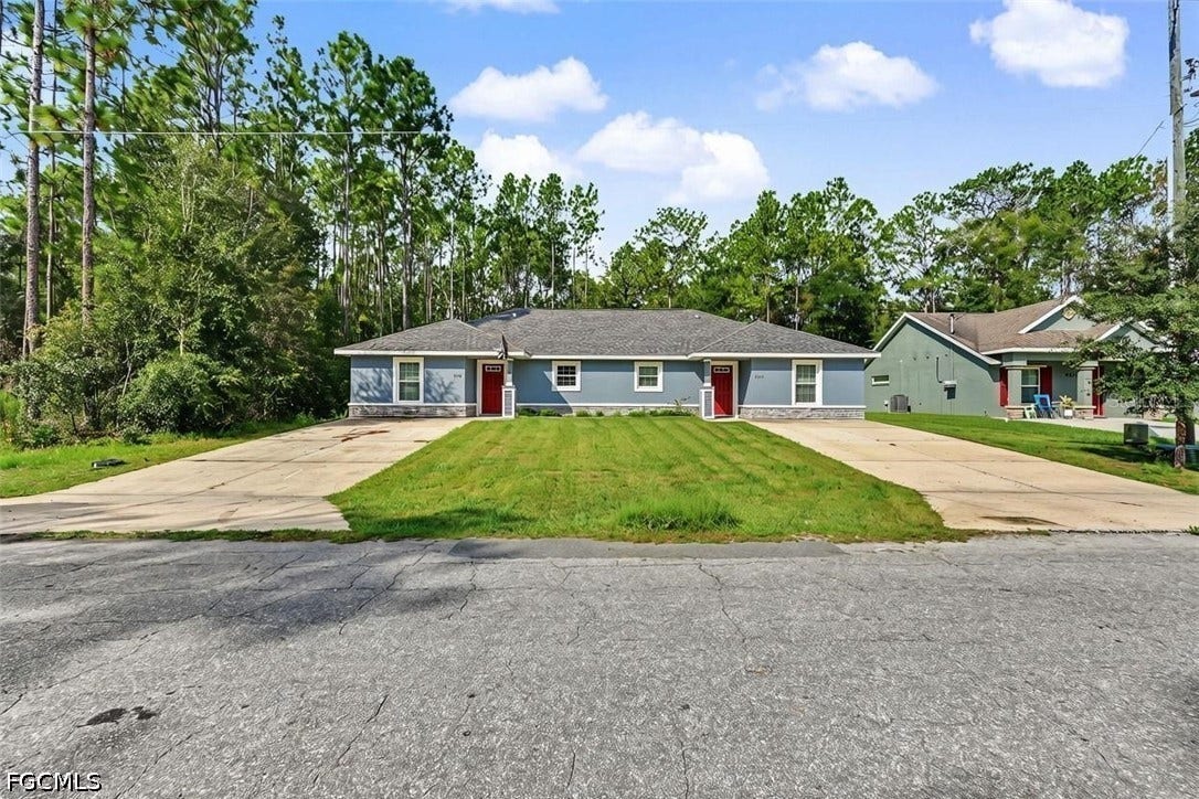 9342/9344 N Peachtree Way, Citrus Springs, FL 34434 Two single-story residences featuring light blue siding with stone accents, red entry doors, and grey shingle roofing
