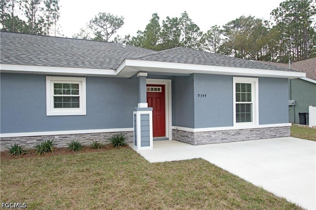 9342/9344 N Peachtree Way, Citrus Springs, FL 34434 Stucco exterior with stone veneer accents, covered entry, and a red front door