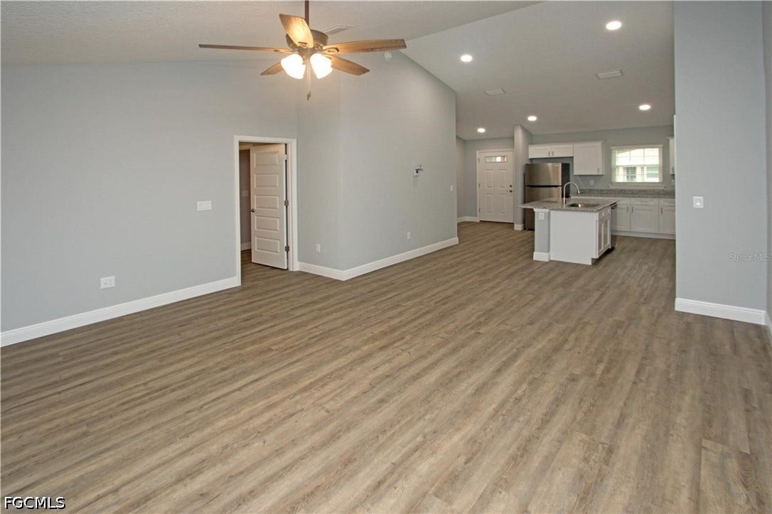 9342/9344 N Peachtree Way, Citrus Springs, FL 34434 Open-concept living space with wood-finish flooring, vaulted ceiling, ceiling fan, and recessed lighting