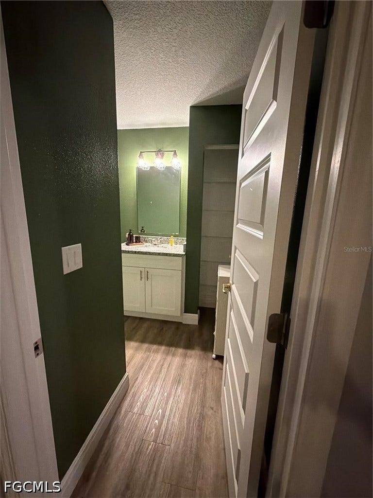 9342/9344 N Peachtree Way, Citrus Springs, FL 34434 Wood-finish flooring throughout, white paneled interior doors, and a vanity with white cabinetry