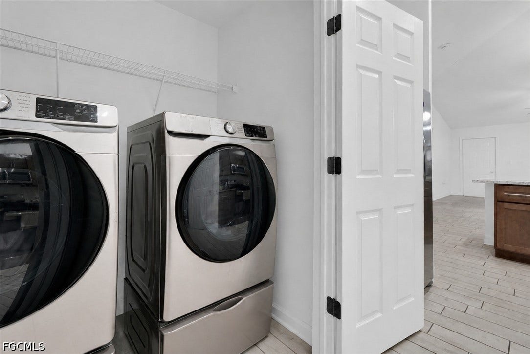 2412/2414 Richard Avenue S, Lehigh Acres, FL 33973 Laundry area featuring tile flooring and a wire storage shelf