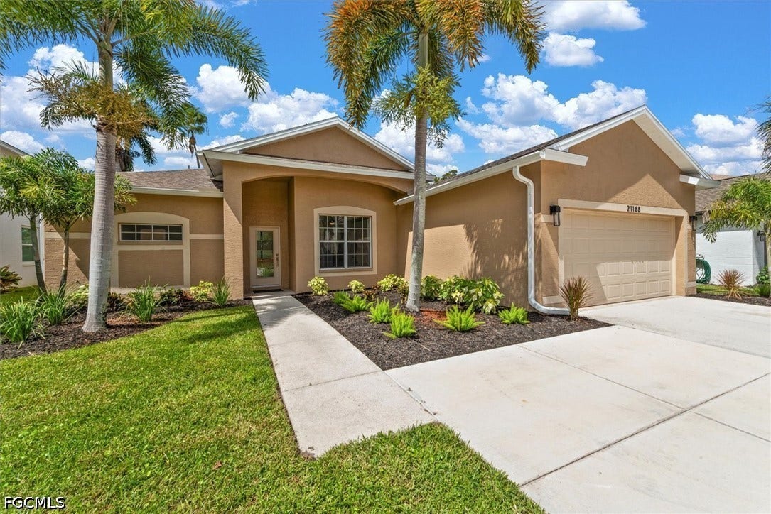 Stucco exterior with a covered entry, attached garage, and a concrete driveway