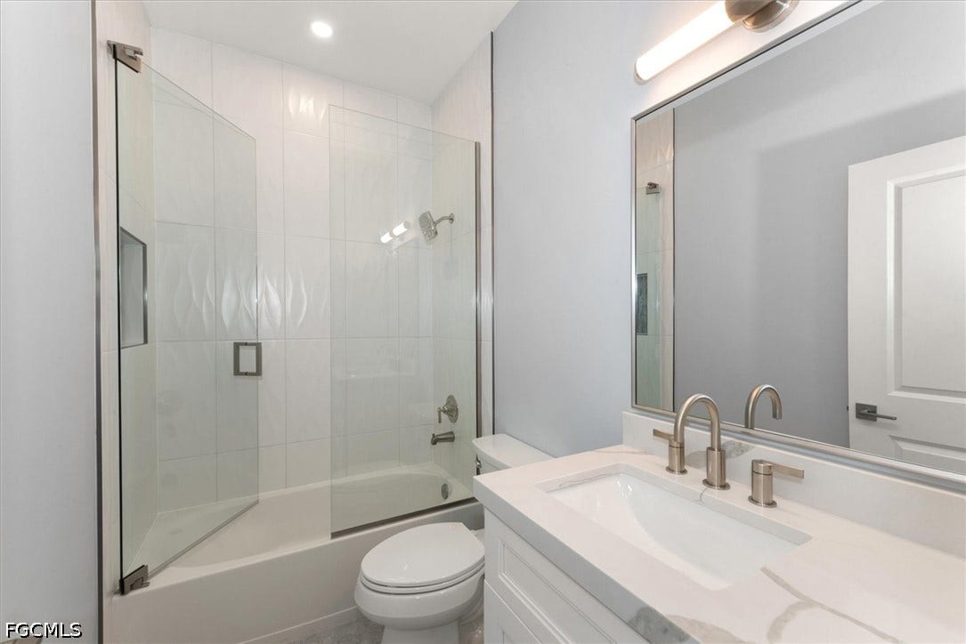 Spa-inspired bathroom featuring a frameless glass-enclosed shower with subway tile surround, floating vanity with quartz countertop and dual sink configuration, large mirror with integrated lighting, and contemporary brushed nickel fixtures throughout