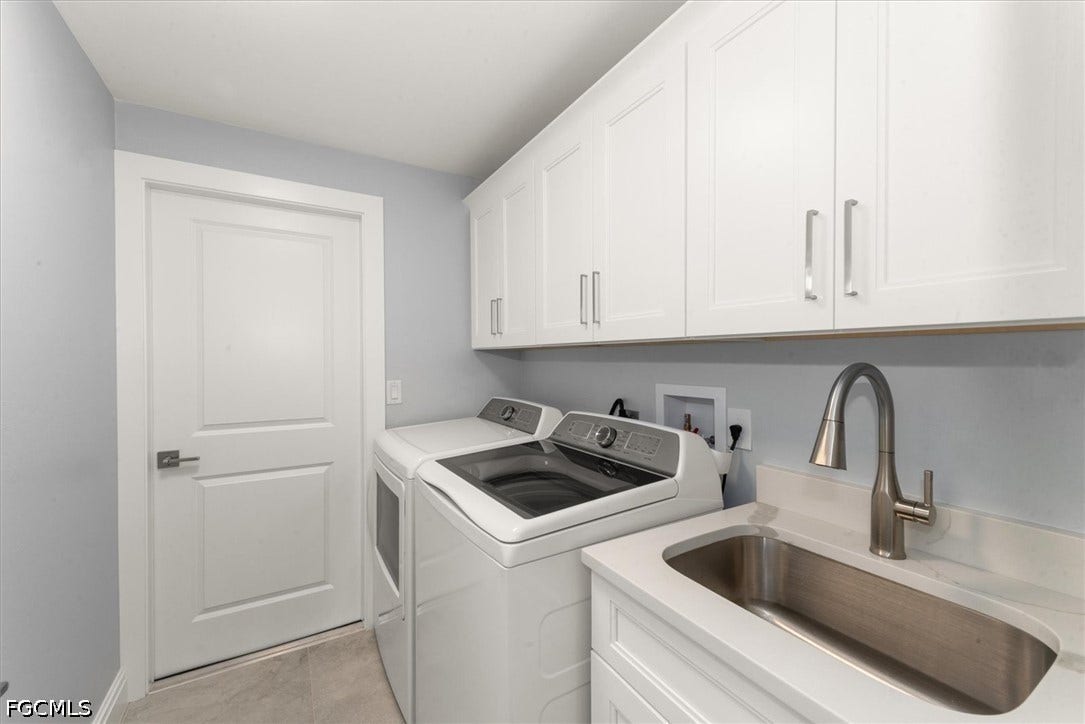 White shaker-style cabinetry, a stainless steel undermount sink, a gooseneck faucet, light-toned flooring, and a white paneled door