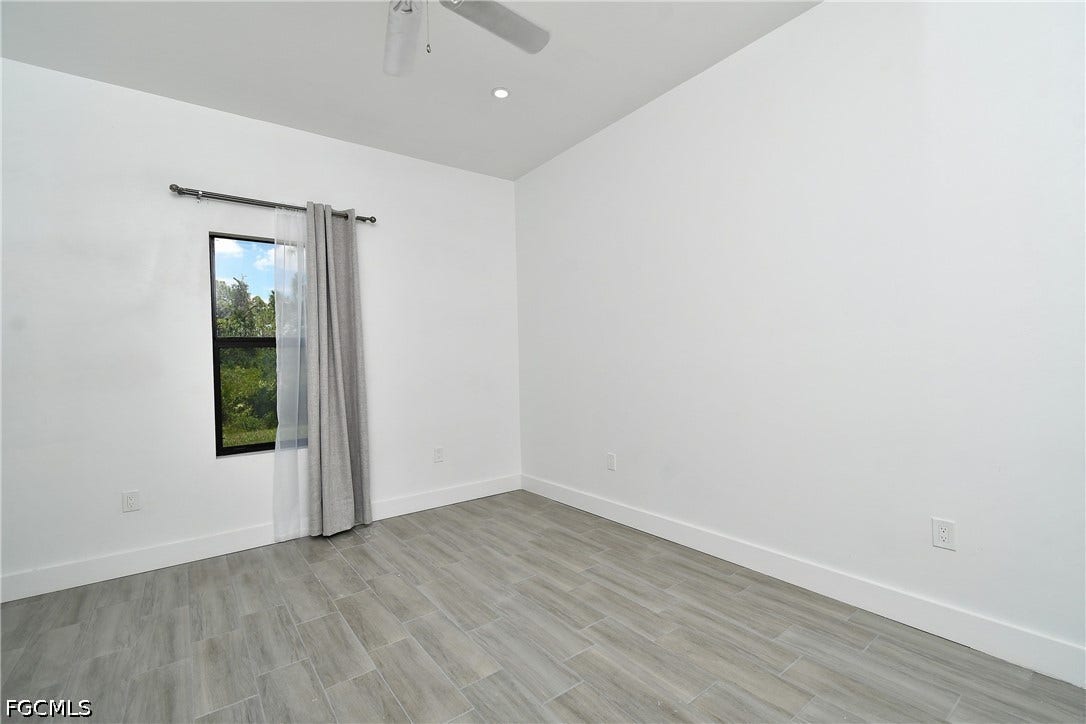 Spare room featuring wood finish floors and a ceiling fan