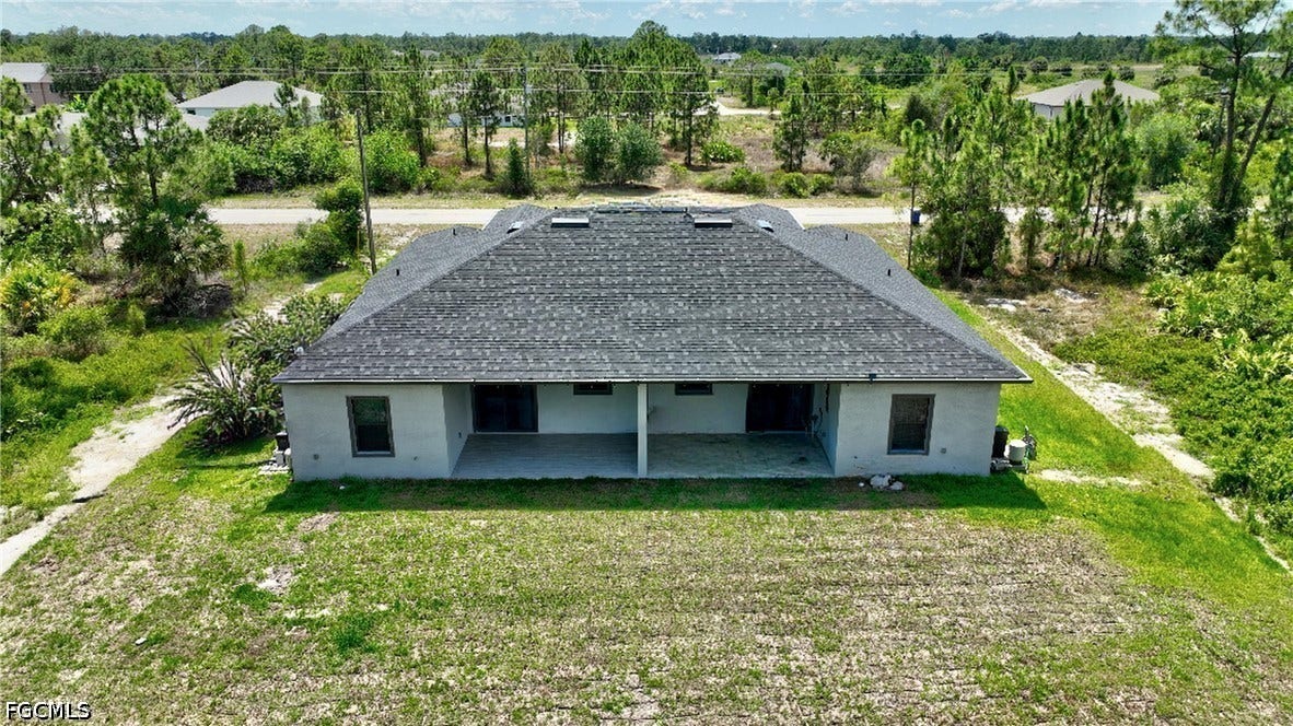 Aerial view of property and surrounding area with a tree filled landscape
