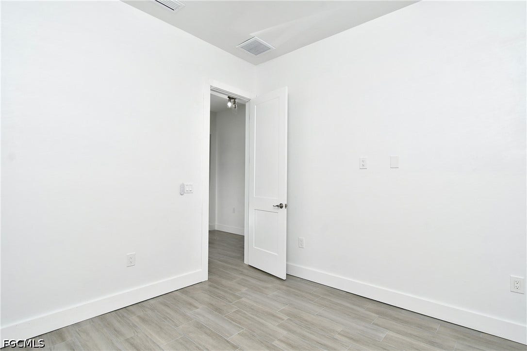 Spare room featuring baseboards and light wood finished floors