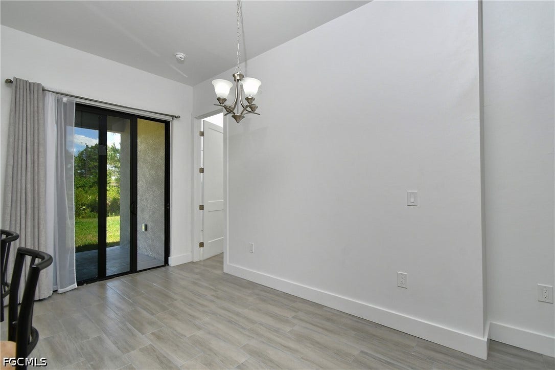 Unfurnished dining area featuring suspended lighting and light wood-style floors