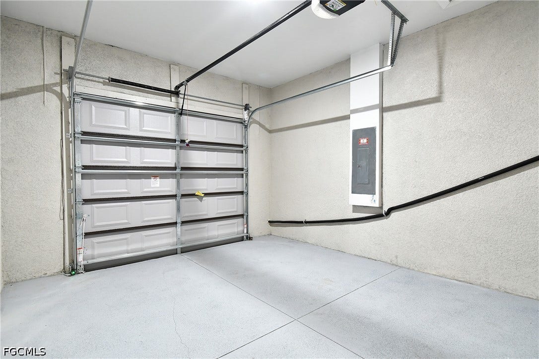 Garage featuring electric panel and a garage door opener