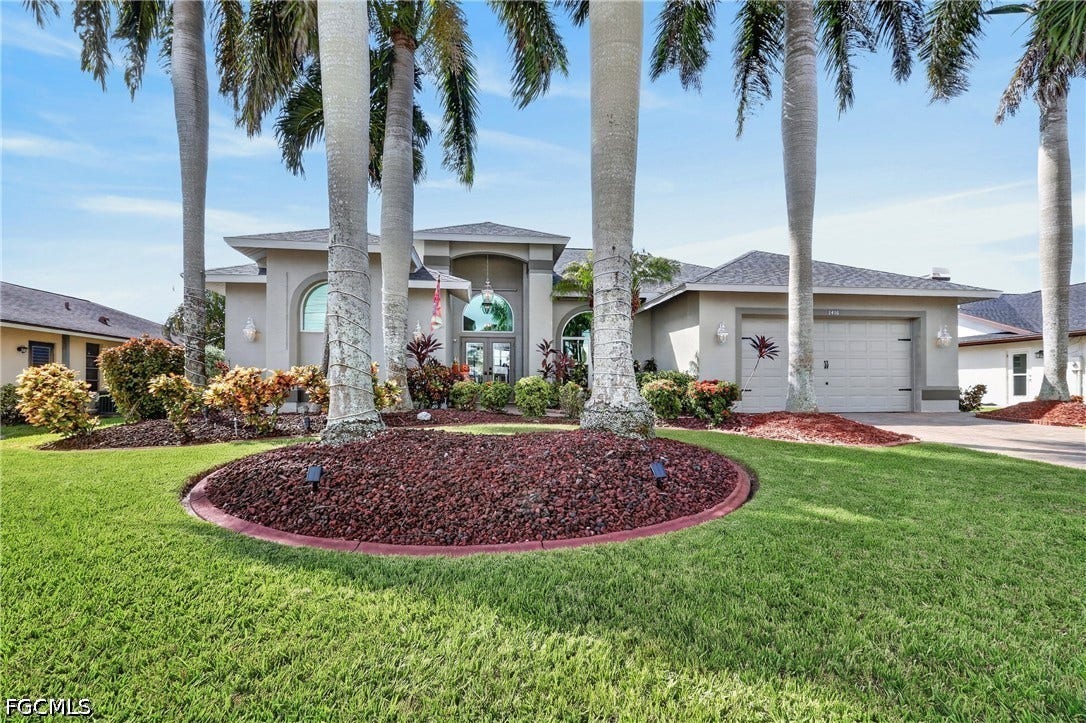 1416 SW 49th Terrace, Cape Coral, FL 33914 Stucco exterior with an arched entryway and double glass doors