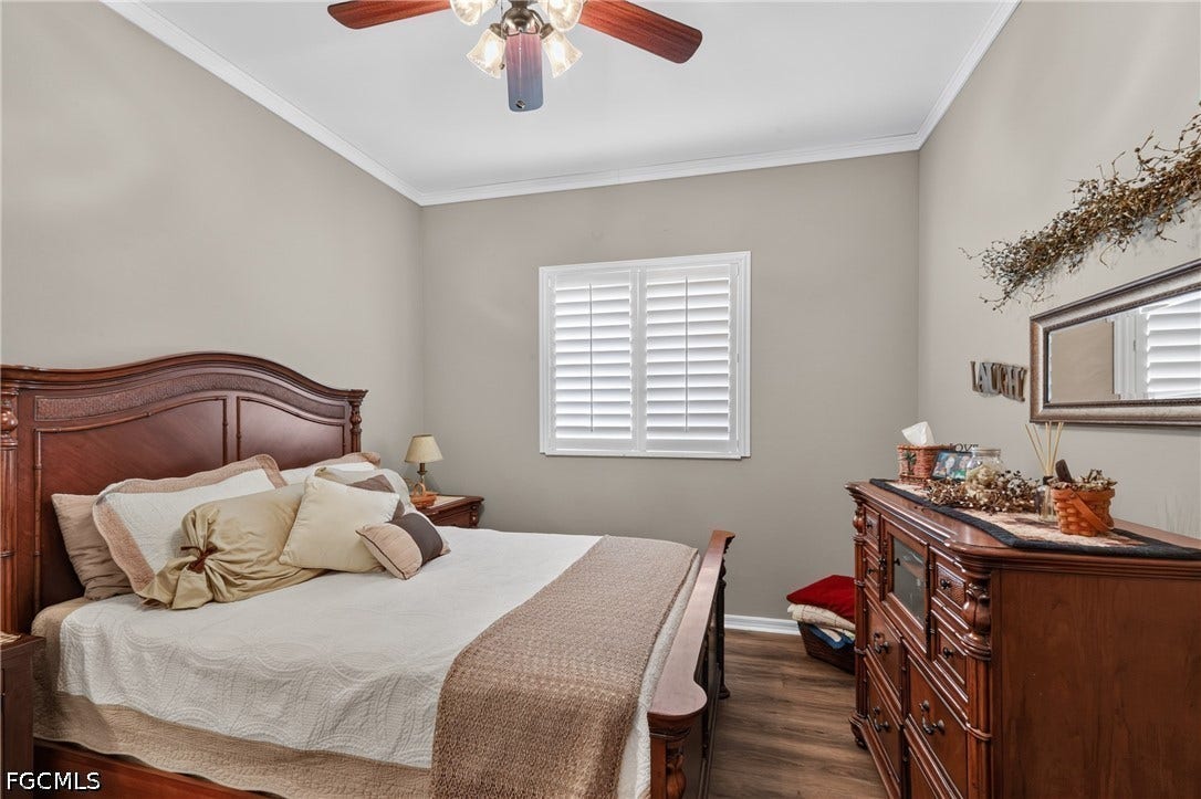 1416 SW 49th Terrace, Cape Coral, FL 33914 Guest Bedroom 1 - Wood-finish flooring, crown molding, ceiling fan, and window with plantation shutters