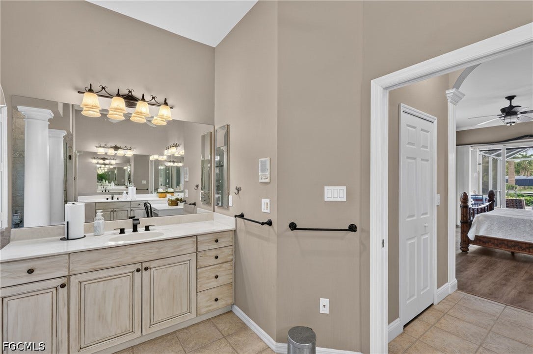 1416 SW 49th Terrace, Cape Coral, FL 33914 Single vanity with an integrated sink, broad wall mirror, and an ornate four-light fixture
