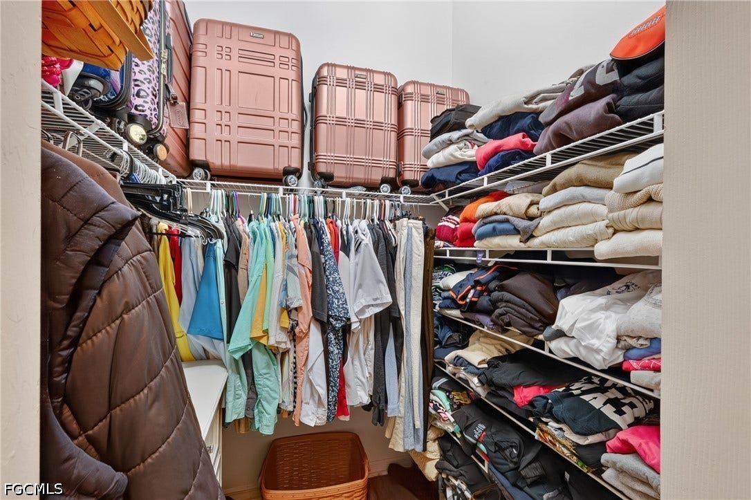 1416 SW 49th Terrace, Cape Coral, FL 33914 Master closest with hydraulic raised hanging rack - White wire shelving system with multiple tiers, hanging rods, and ample storage space