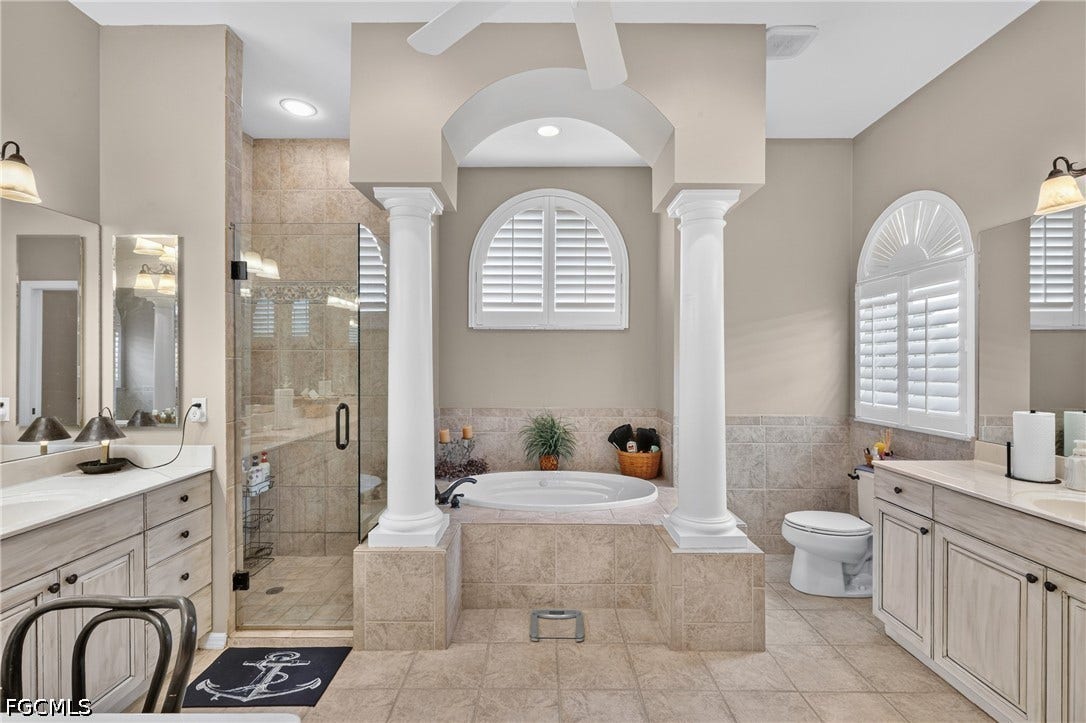 1416 SW 49th Terrace, Cape Coral, FL 33914 Dual vanities with undermount sinks, walk-in shower with glass enclosure, soaking tub, two arched windows with plantation shutters, and tile flooring