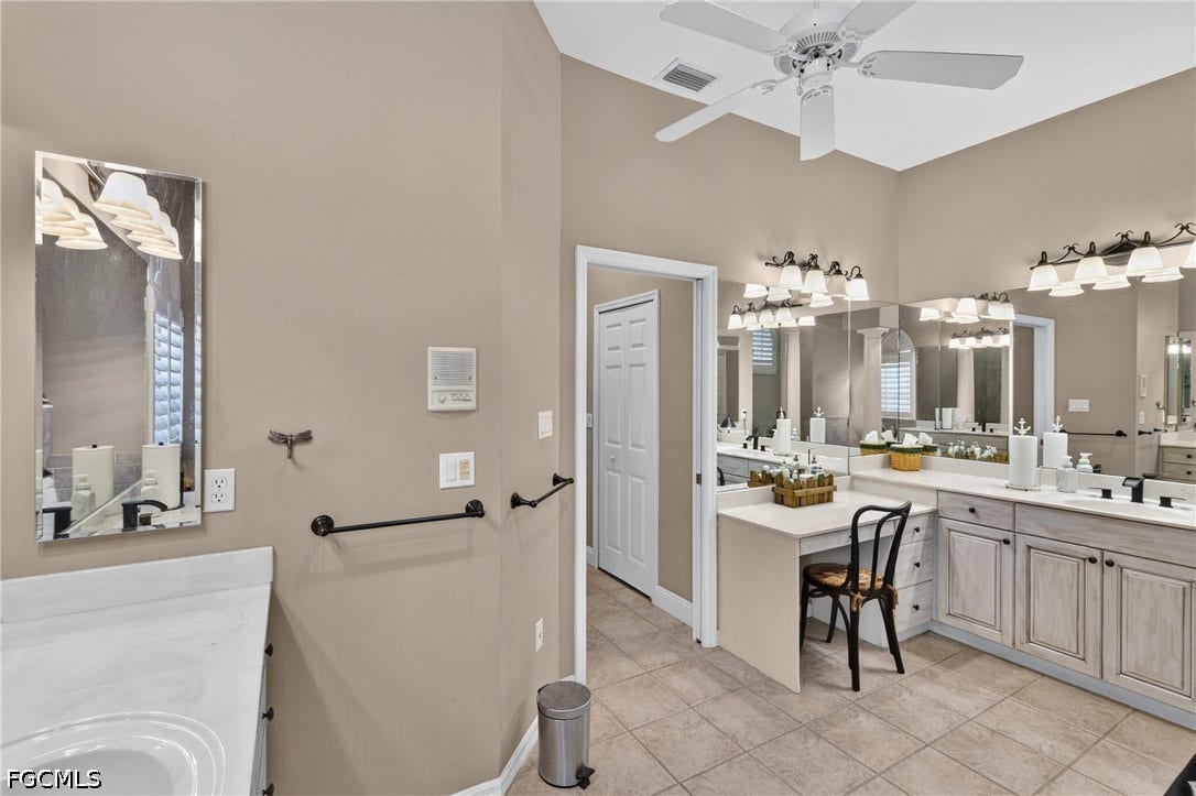 1416 SW 49th Terrace, Cape Coral, FL 33914 Vaulted ceiling with a ceiling fan, dual vanity with undermount sinks, vanity mirrors, built-in vanity station, and tiled flooring