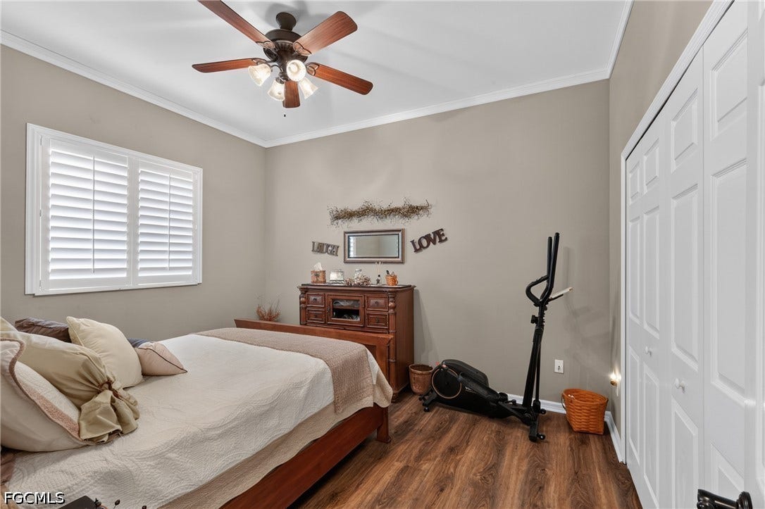 1416 SW 49th Terrace, Cape Coral, FL 33914 Guest bedroom 1 - Wood-finish flooring, white plantation shutters, ceiling fan with integrated lighting, and bi-fold closet doors