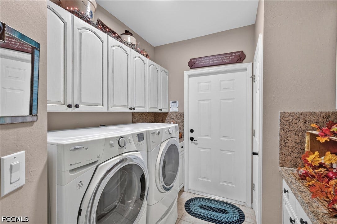 1416 SW 49th Terrace, Cape Coral, FL 33914 White cabinetry, light-toned walls, and a textured countertop