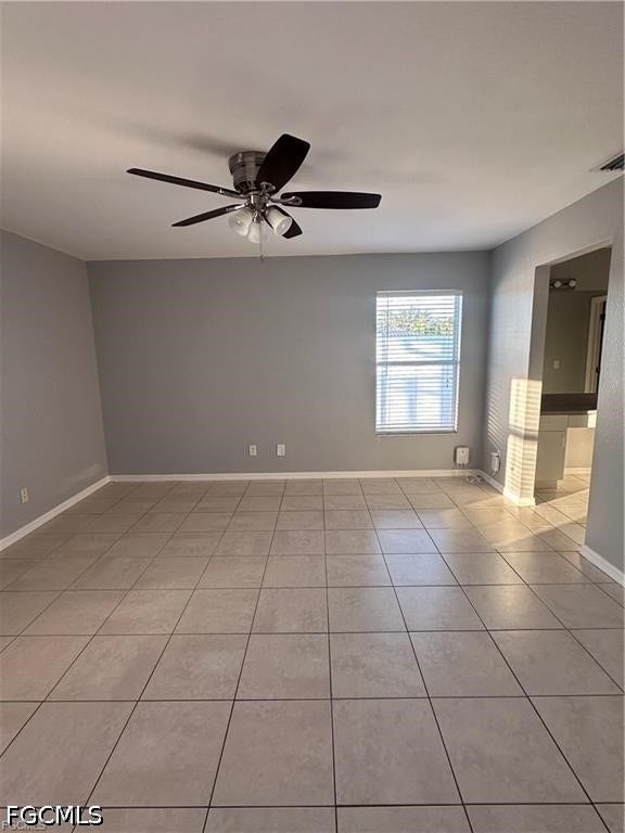2926 SE Santa Barbara Place, Cape Coral, FL 33904 Neutral-toned tile flooring, ceiling fan with integrated lighting, and window with horizontal blinds