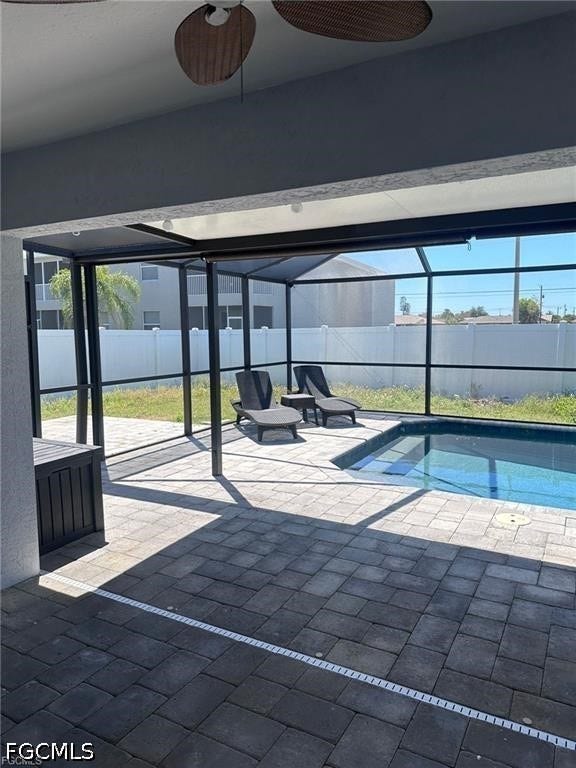 2926 SE Santa Barbara Place, Cape Coral, FL 33904 Screened lanai with paver decking, an integrated swimming pool, and a white privacy fence