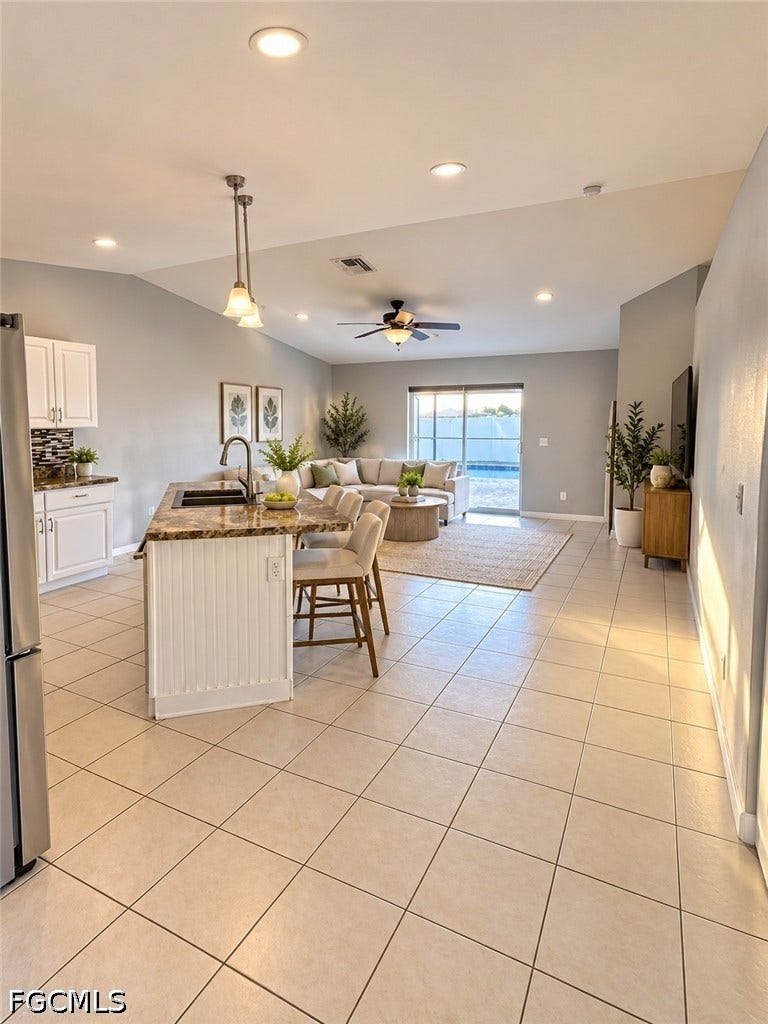 2926 SE Santa Barbara Place, Cape Coral, FL 33904 Open-concept living space with tile flooring, a kitchen island with a stone-finish countertop, recessed lighting, and a ceiling fan