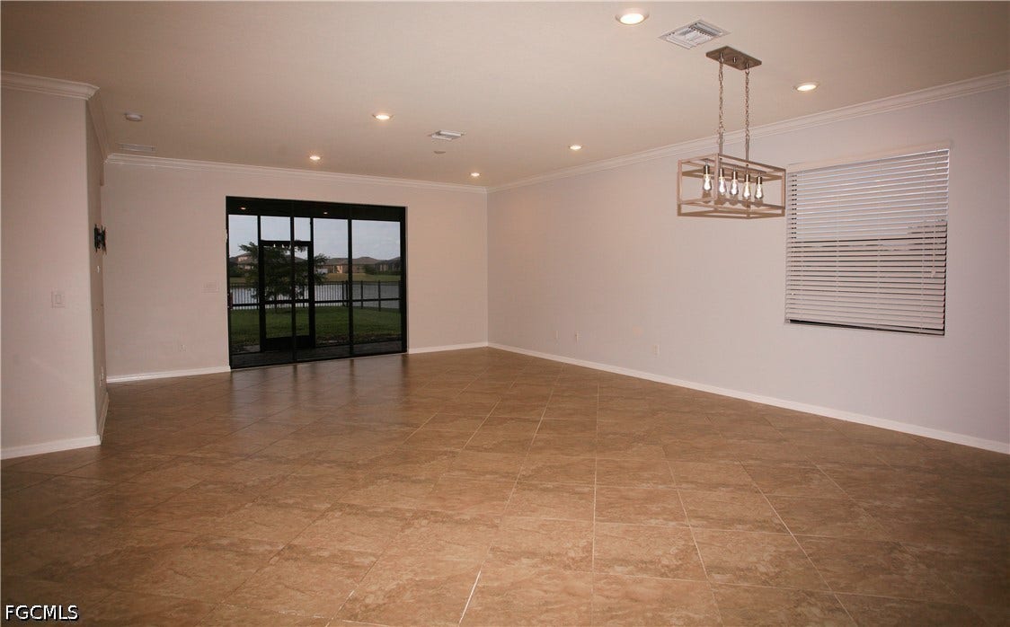14495 Vindel Circle, Fort Myers, FL 33905 Spacious room with large format tile flooring, crown molding, recessed lighting, and a contemporary chandelier