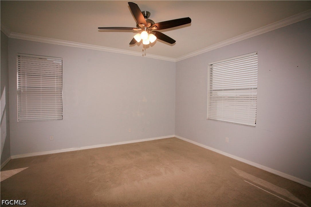 14495 Vindel Circle, Fort Myers, FL 33905 Wall-to-wall carpeting with multiple windows, crown molding, and a ceiling fan with integrated lighting