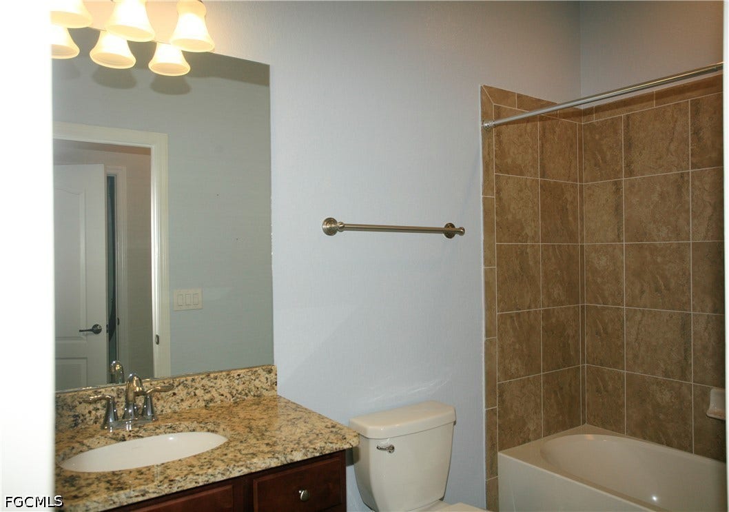 14495 Vindel Circle, Fort Myers, FL 33905 Bathroom featuring a vanity with a granite countertop, undermount sink, and chrome faucet