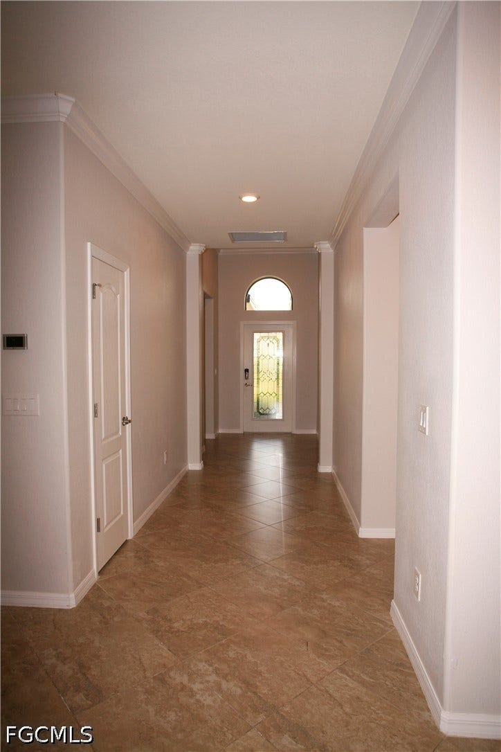 14495 Vindel Circle, Fort Myers, FL 33905 Long entryway featuring diagonal tile flooring, crown molding, recessed lighting, and a front door with an arched transom window and decorative glass insert