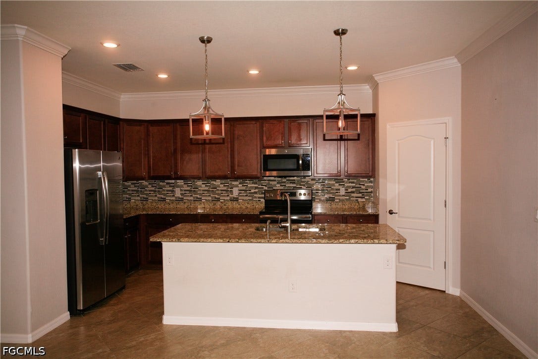14495 Vindel Circle, Fort Myers, FL 33905 Kitchen featuring dark wood-finish cabinetry, stainless steel appliances, granite countertops, and a mosaic tile backsplash