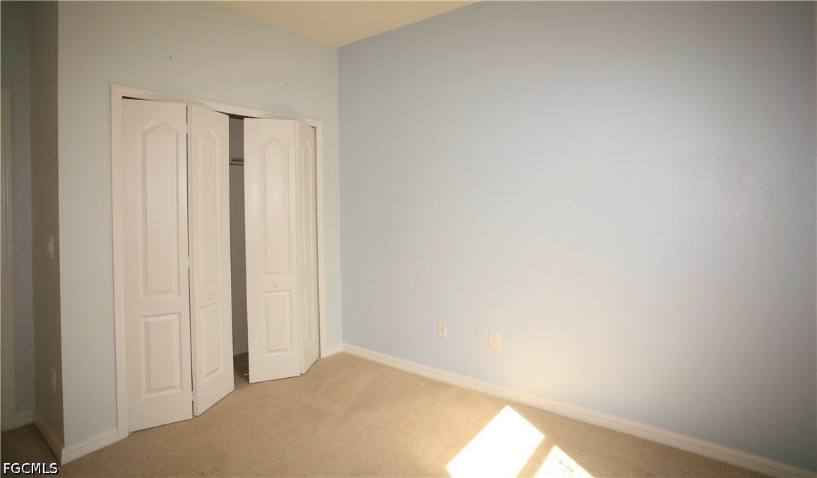 14495 Vindel Circle, Fort Myers, FL 33905 Light-colored carpeting, blue-painted walls, and white bi-fold closet doors