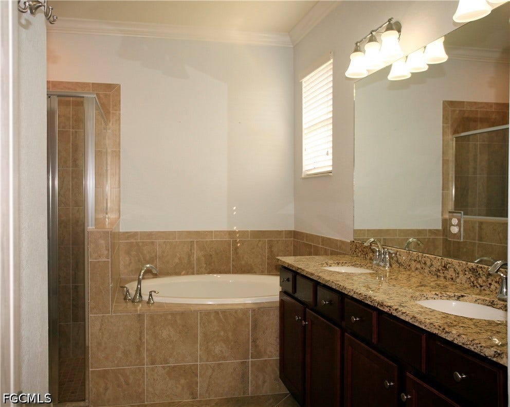 14495 Vindel Circle, Fort Myers, FL 33905 Built-in soaking tub, separate glass-enclosed shower, dual vanity with undermount sinks, and a stone countertop