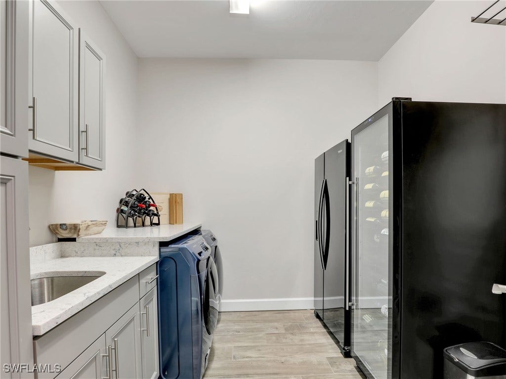 Spacious Laundry Room with upgraded cabinets and convenient sink