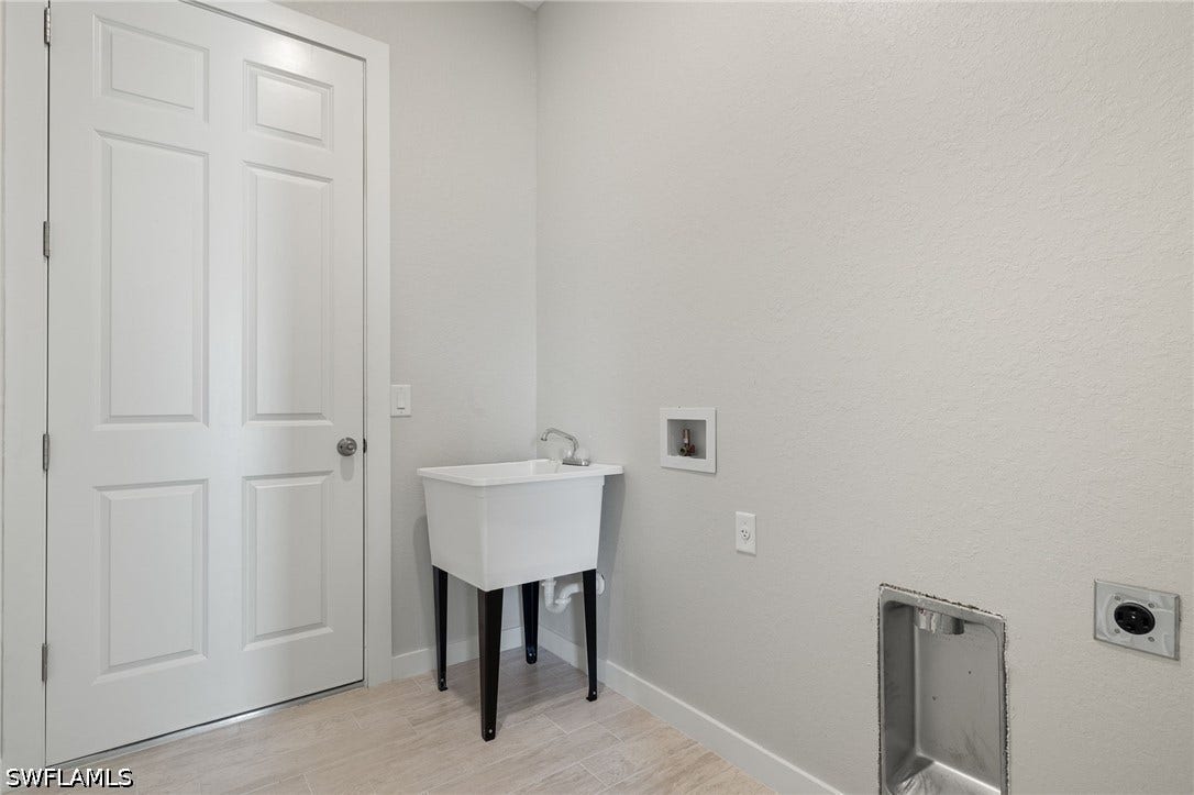 Laundry room with Laundry tub. Flooring upgraded to premium, color-matched Luxury Vinyl Plank [LVP].