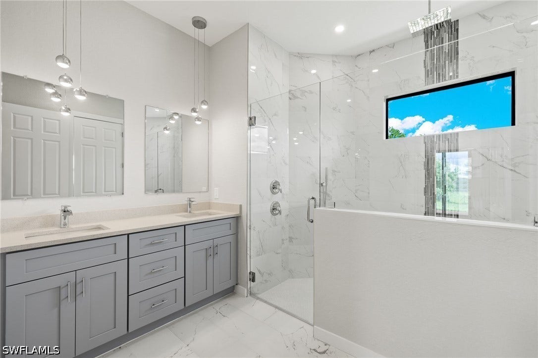 4713 6th Street W, Lehigh Acres, FL 33971 En-suite bathroom with dual quartz vanities, premium lighting & custom XL shower