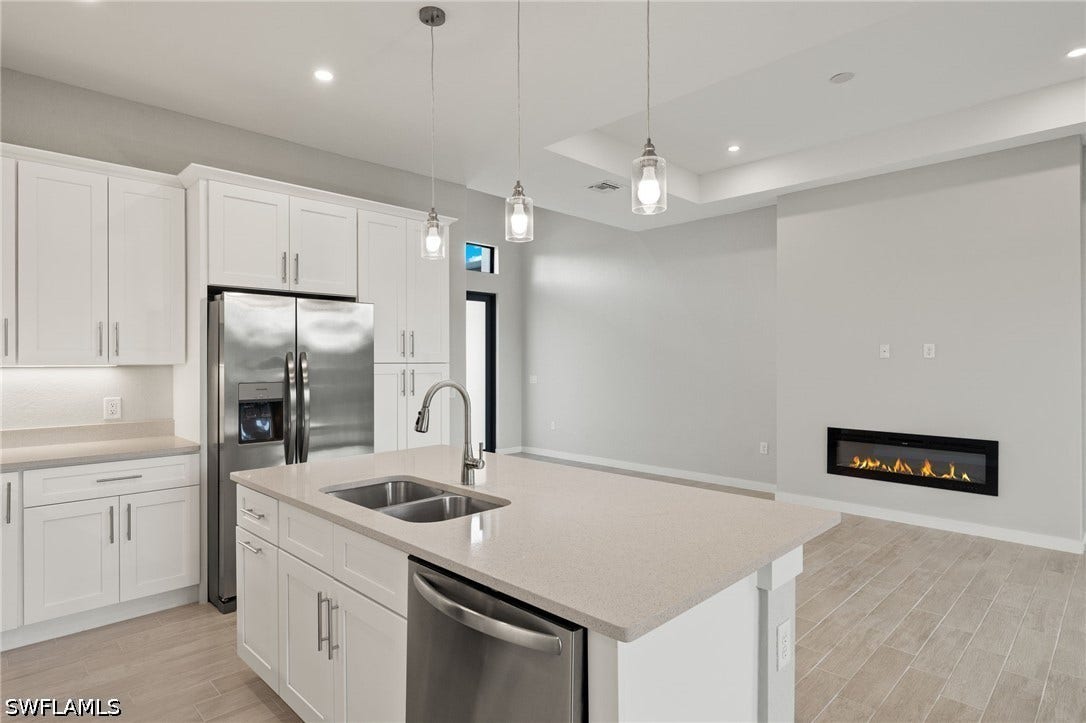 4713 6th Street W, Lehigh Acres, FL 33971 Gourmet kitchen with quartz island, shaker cabinets, and premium luxury vinyl plank (LVP) flooring upgrade.