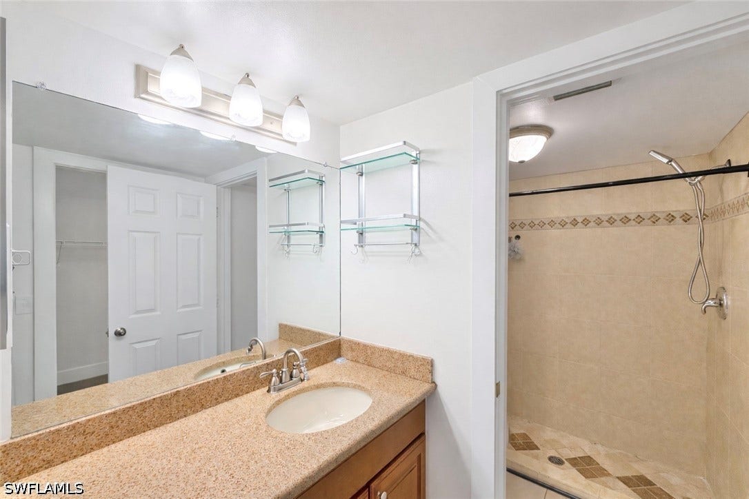 Full bathroom with vanity and a shower stall