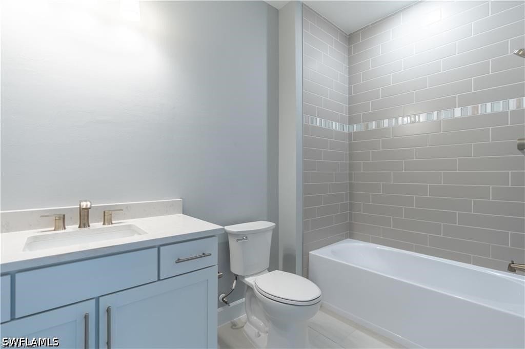 White vanity with a light-toned countertop and an undermount sink