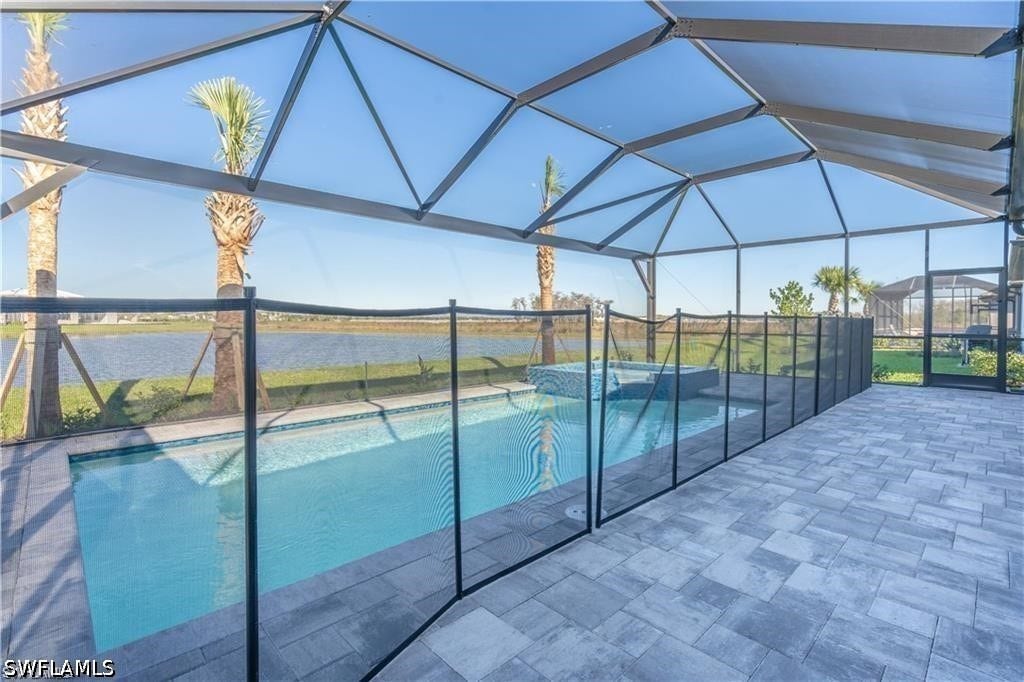 Screened lanai featuring a swimming pool, integrated spa, and paver decking