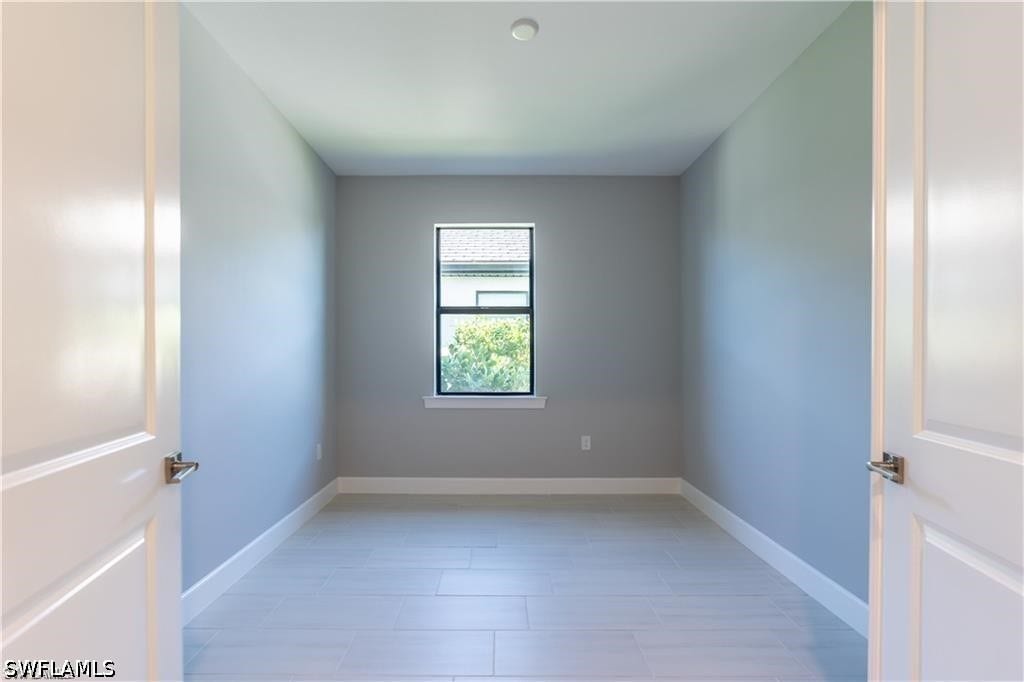 Recessed ceiling light, light-toned walls, white baseboards, window with dark trim, and light wood-finish flooring