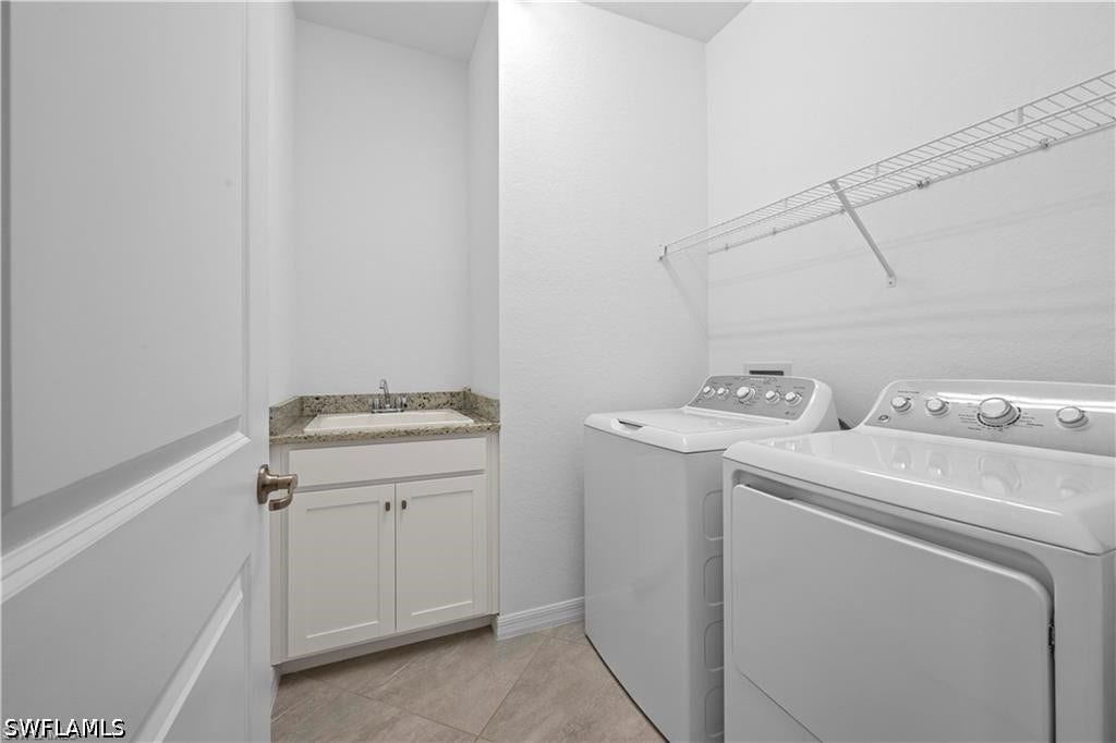 Laundry area featuring a utility sink, light-toned countertop, white cabinetry, and wire shelving