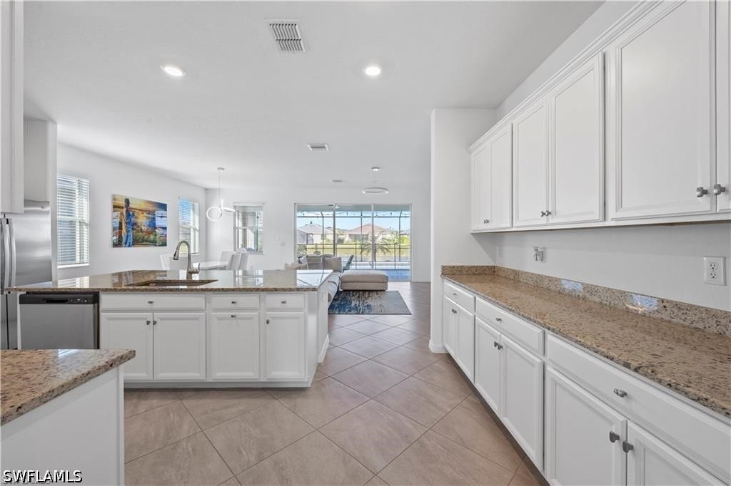 Kitchen featuring white cabinetry, light-toned countertops, stainless steel appliances, and tiled flooring